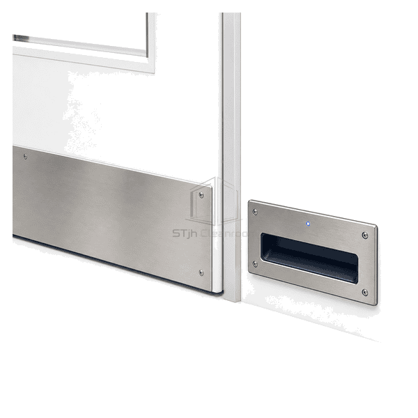 Foot-operated switch installed low beside a cleanroom door